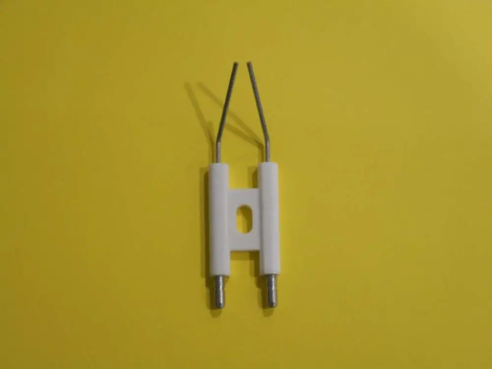 Elektrodenblock für Heizsysteme, hergestellt von Remeha. Das Produkt hat eine weiße Kunststoffbasis mit zwei Metallstiften und einer mittigen Öffnung.